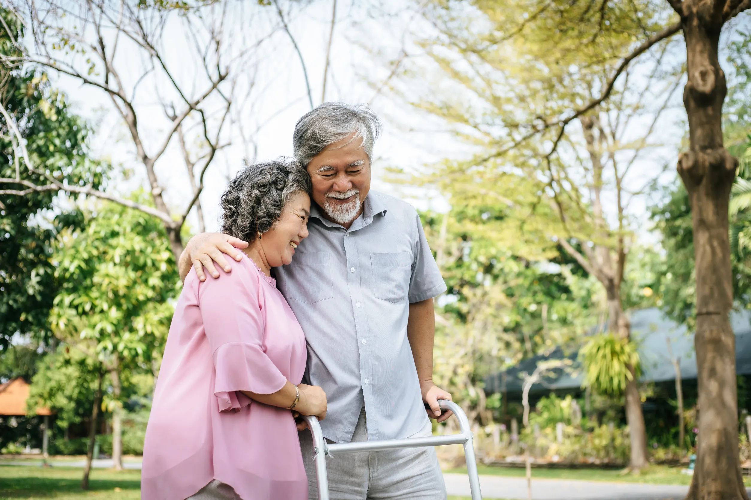 assisting her senior patient who's using a walker for support
